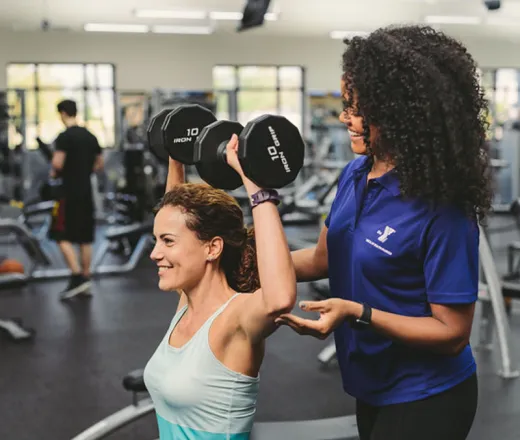 Personal Trainer helps woman work out at the YMCA